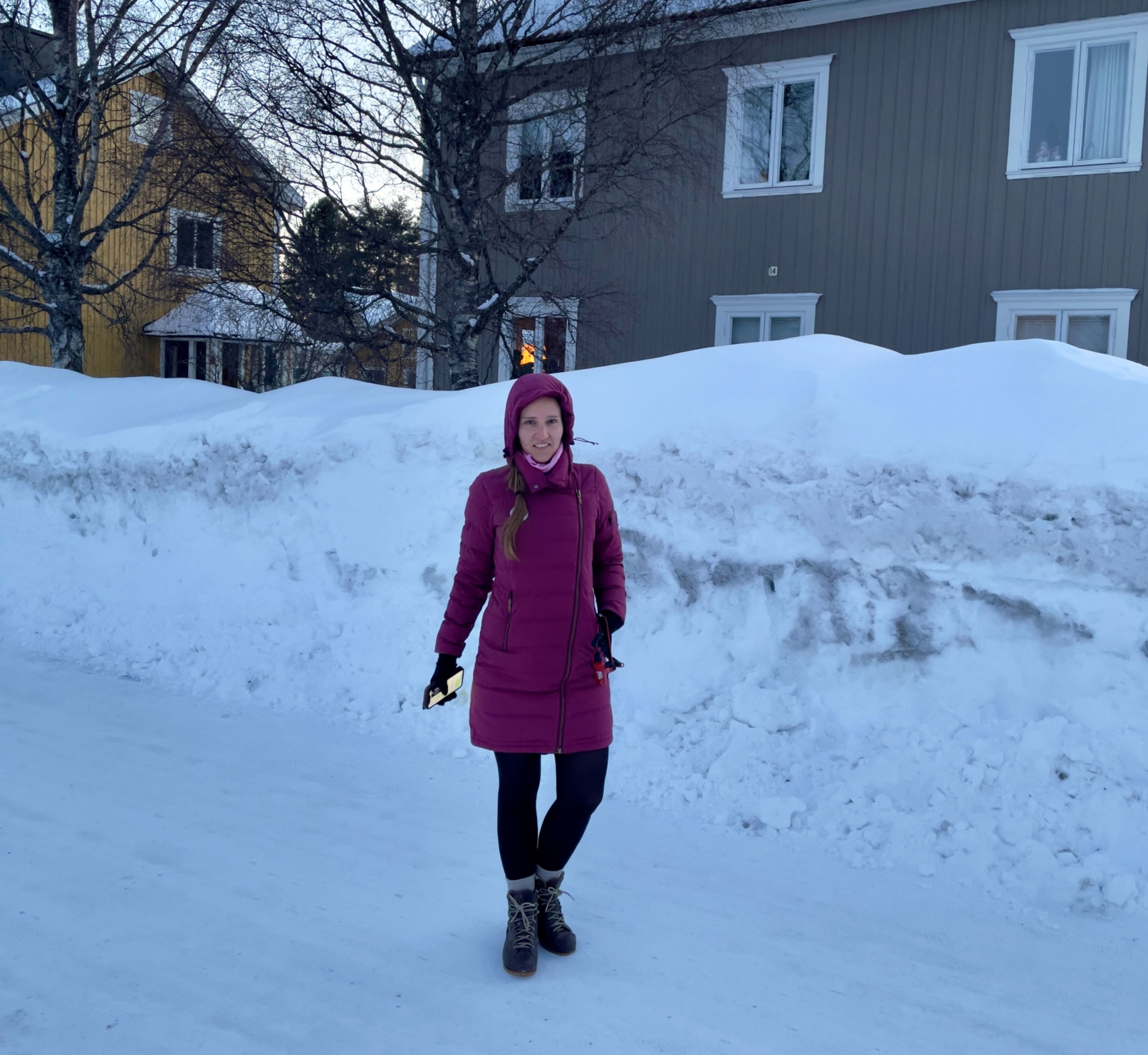 Verena in front of a big pile of snow